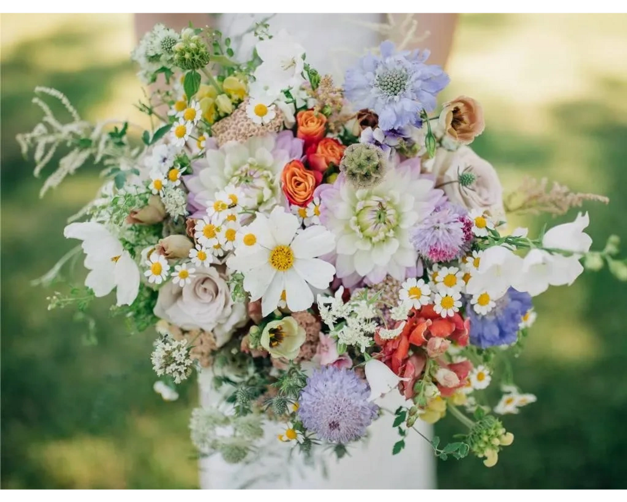 A bride holding a bouquet of flowers in various colors on her wedding day from Bend Wedding Florist.