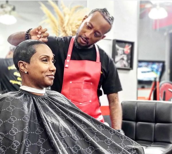 Woman with a fresh haircut smiling at a barber's shop.