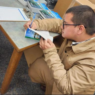 Man signing a book at a table.