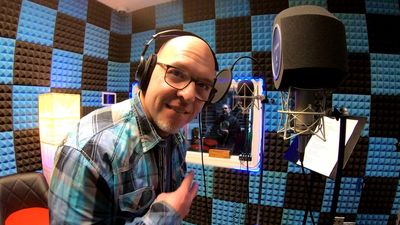 Man wearing headphones in a soundproof recording studio.