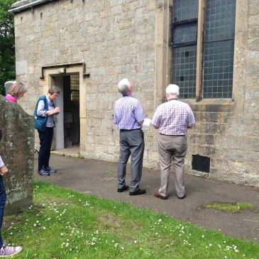 People standing outside a stone building.