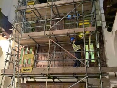 Worker on scaffolding inside a building.