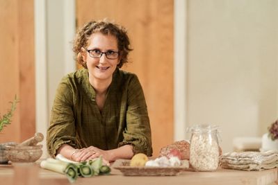 Helen Moorhouse leaning on worktop in kitchen with prebiotic rich food to support Gut Health