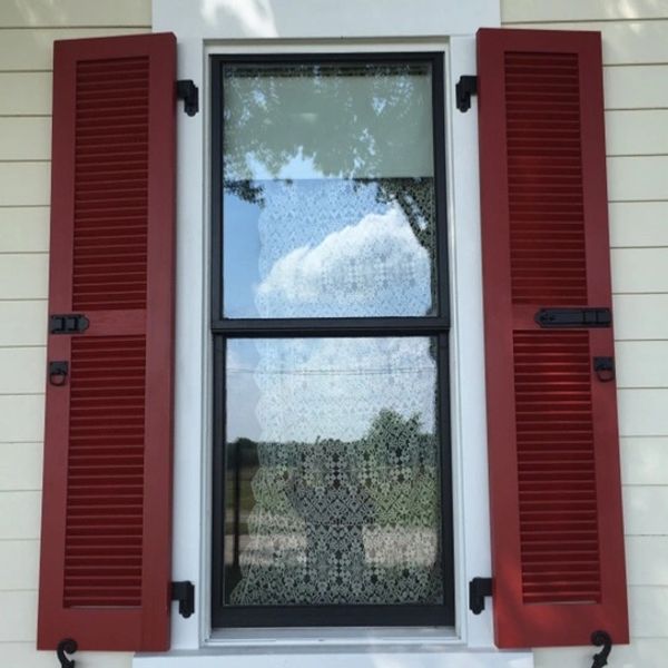 Red shutters on a white sided house 