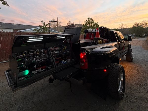 Black pickup truck with organized tool storage at sunset.