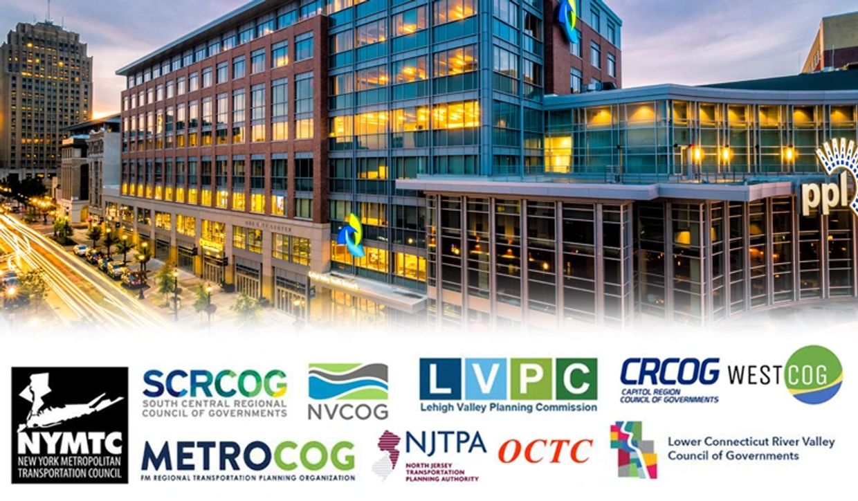 Cityscape with illuminated modern building and transportation council logos below.