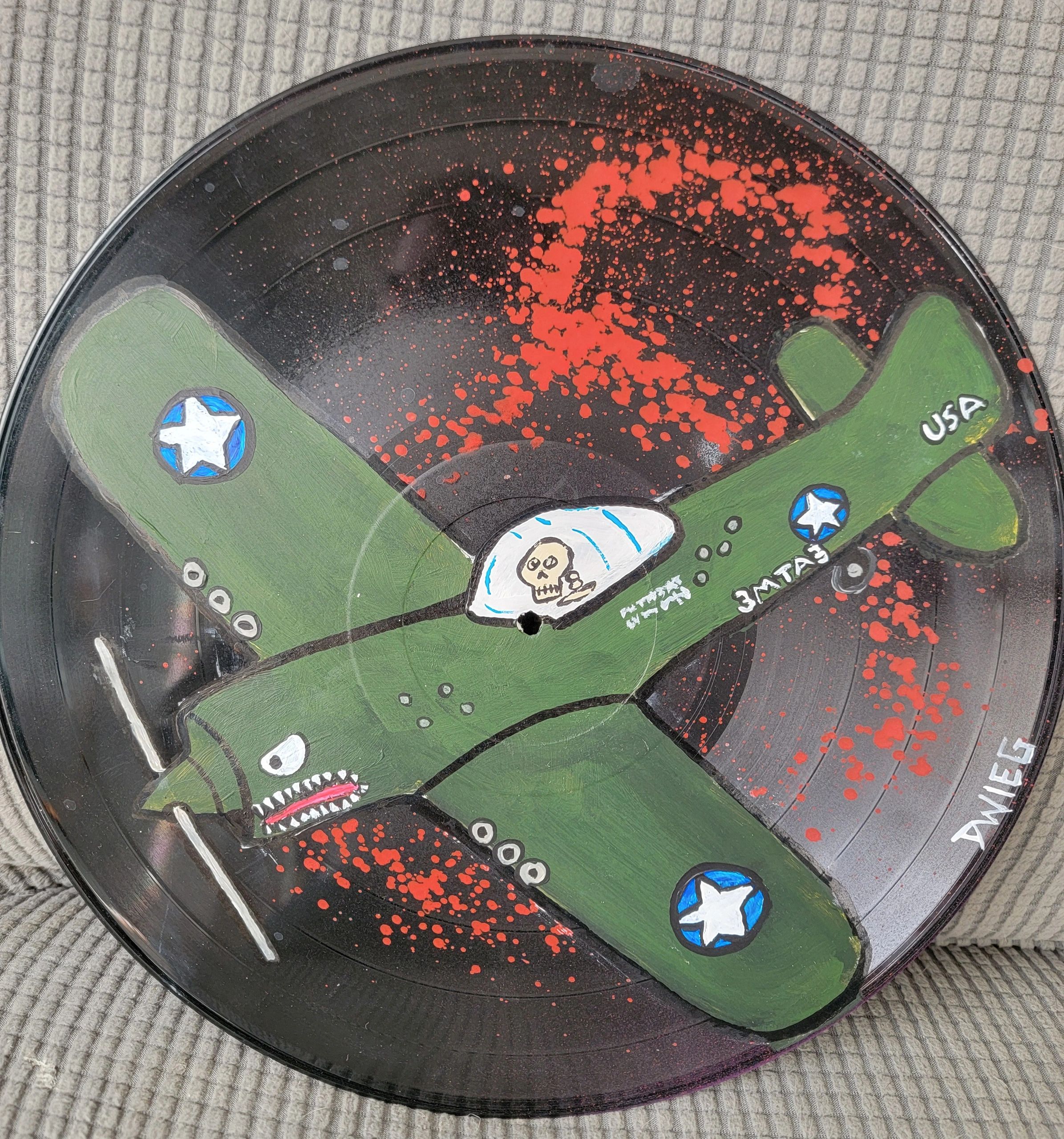 Hand-painted vinyl record with military plane design and red splatter.