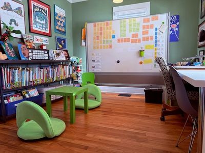 Colorful home office with green chairs and wall post-it notes.