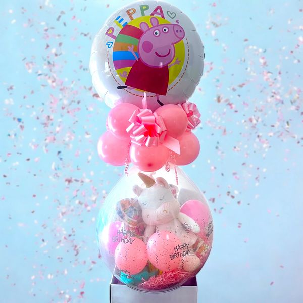 Colorful Peppa Pig birthday balloon with a unicorn plush inside a transparent balloon.