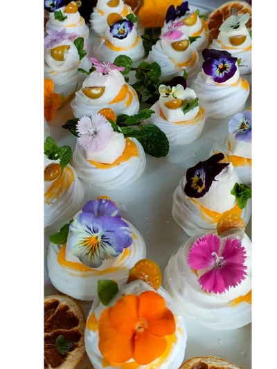 Pavlova bites with edible flowers, lemon curd and cream. Summer desserts. Easy Dessert Pavlova