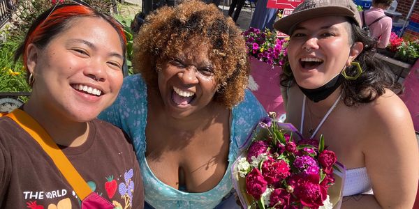 Ebony smiles for a selfie with two volunteers