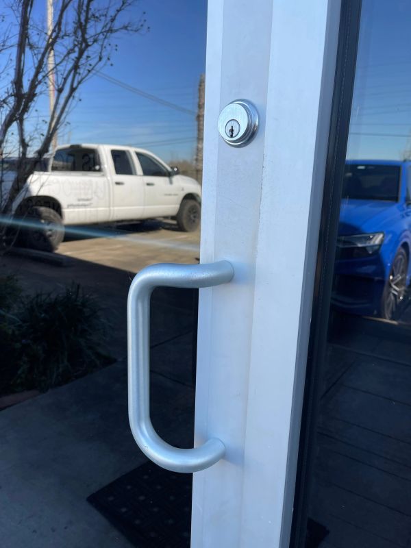Close-up of a silver door handle on a glass door.