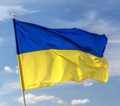 The Ukrainian flag waving against a blue sky.