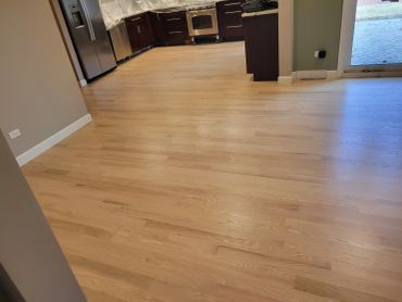 Newly installed light wooden flooring in a modern kitchen area.