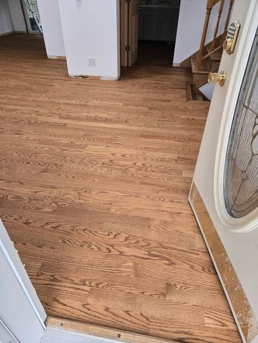 Newly installed wooden floor inside a house entrance.