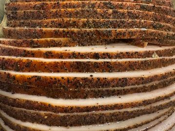 Close-up of sliced seasoned meat with pepper crust.