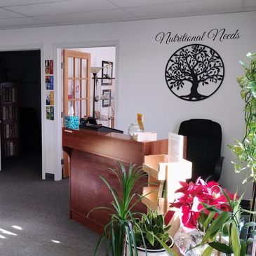 Reception area with plants and a "Nutritional Needs" wall decoration.