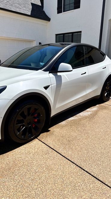 White Tesla model Y parked in front of house