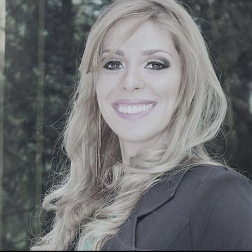 Smiling woman with long blonde hair and elegant makeup.