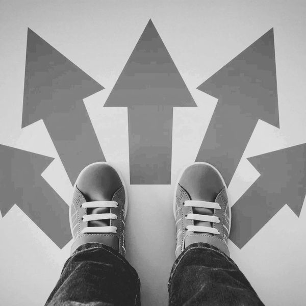 Person standing with feet showing only and 5 arrows pointing in different directions. 