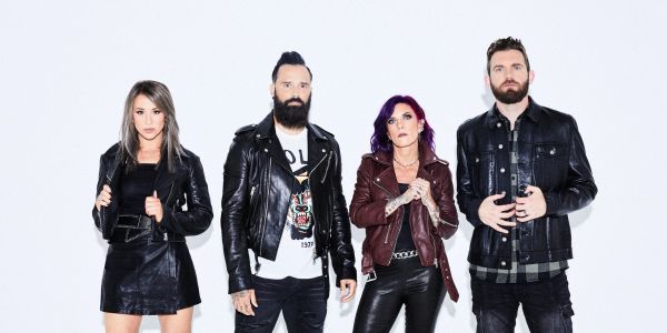Four people dressed in leather jackets posing against a white background.