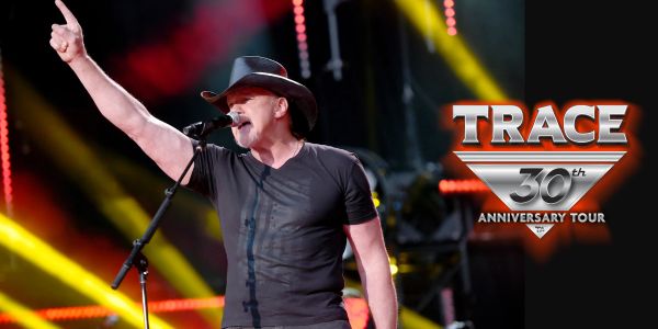 Singer Trace performing live on stage during his 30th anniversary tour.