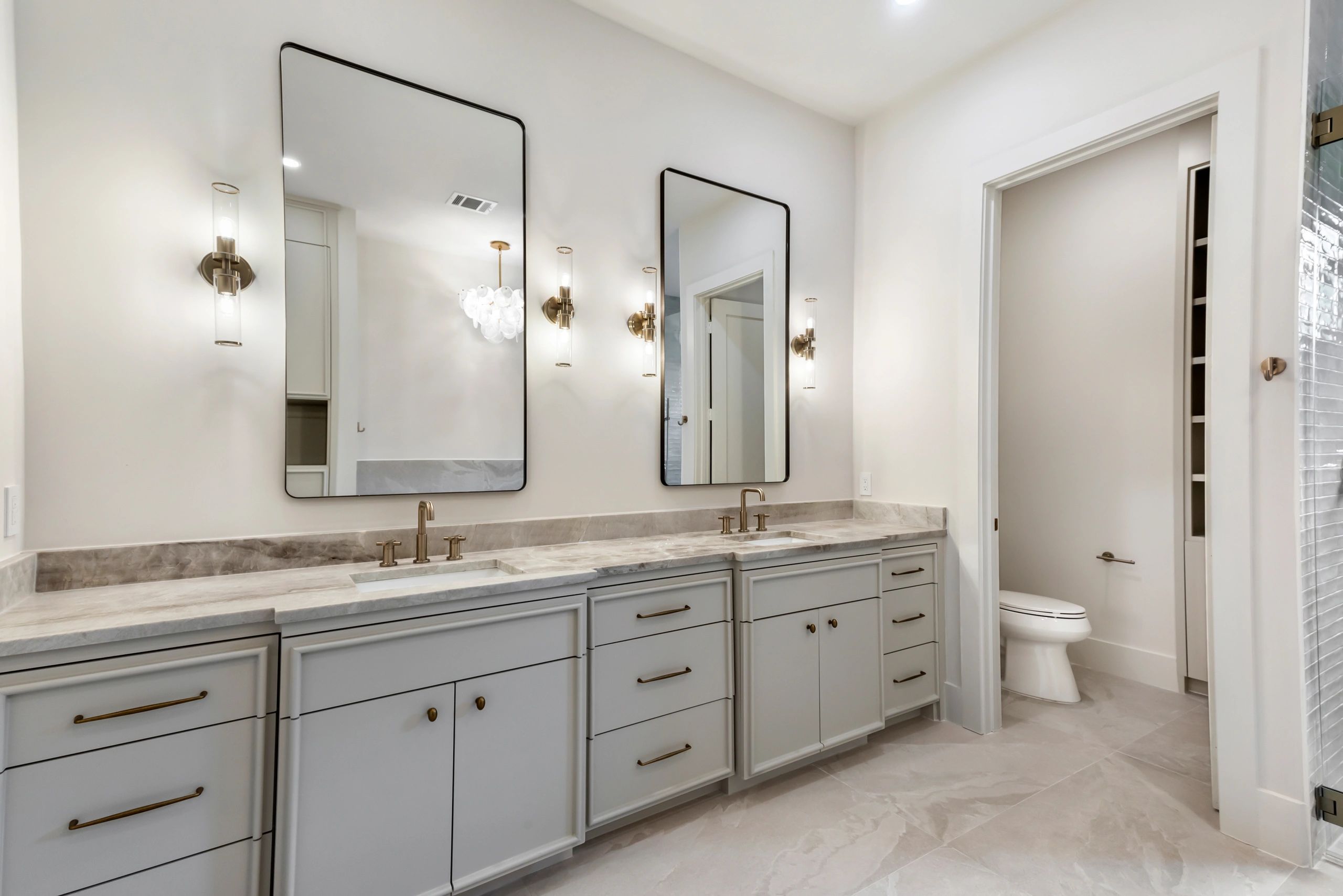 Modern bathroom with double vanity and marble countertop.