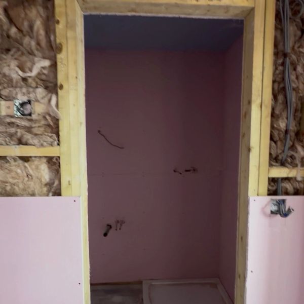 Under-construction bathroom with insulation and framed walls.