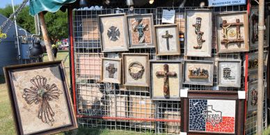 Display of various handcrafted crosses and art pieces at an outdoor market.
