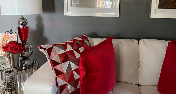 Interior design living room, bird photo living room, red pillows, white sofa, red white room design, gray wall, white gray red design