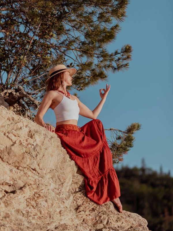 Gyan Mudra, Yoga, Sun, woman, long skirt, hat, rocks, blue sky. white top