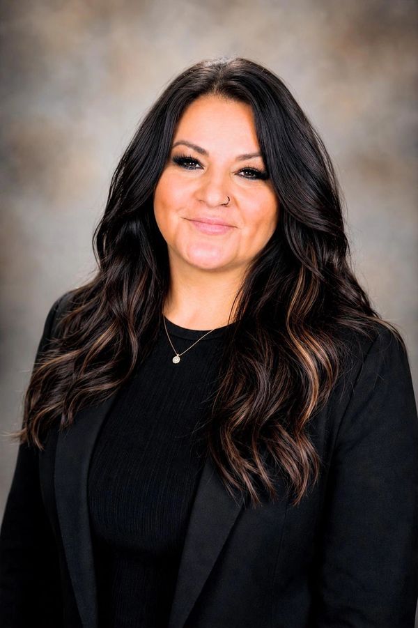 Professional woman with long dark hair and a black blazer.