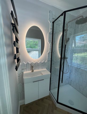 Modern bathroom with marble tiles, floating basin and led mirror 