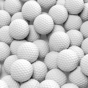 Close-up of numerous white golf balls clustered together.