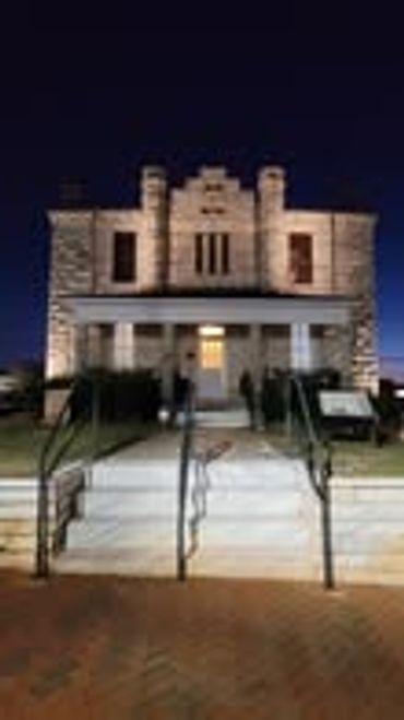 Historic stone building illuminated at night with steps leading up.