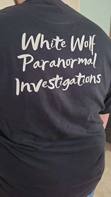Person wearing a black t-shirt with "White Wolf Paranormal Investigations" printed on the back.