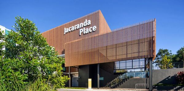 Modern building entrance with wooden facade labeled Jacaranda Place.