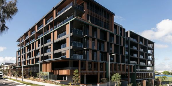 Modern multi-story residential building with balconies and contemporary design.
