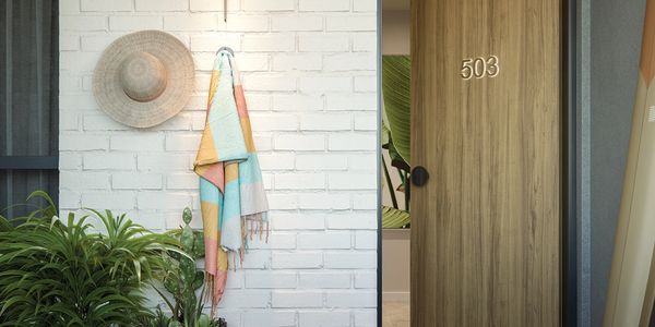 Cozy entrance with a wooden door numbered 503, a colorful towel, and a hanging straw hat.