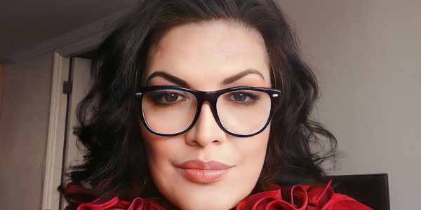 Woman wearing glasses with curly hair styled.
