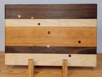 This is one of our most popular boards. It is handcrafted from walnut, maple, and cherry. The plugs 
