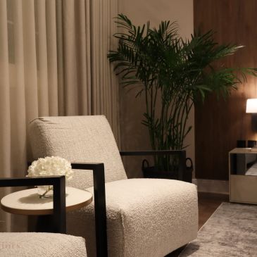 Salon cosy avec fauteuils blancs et plante verte.