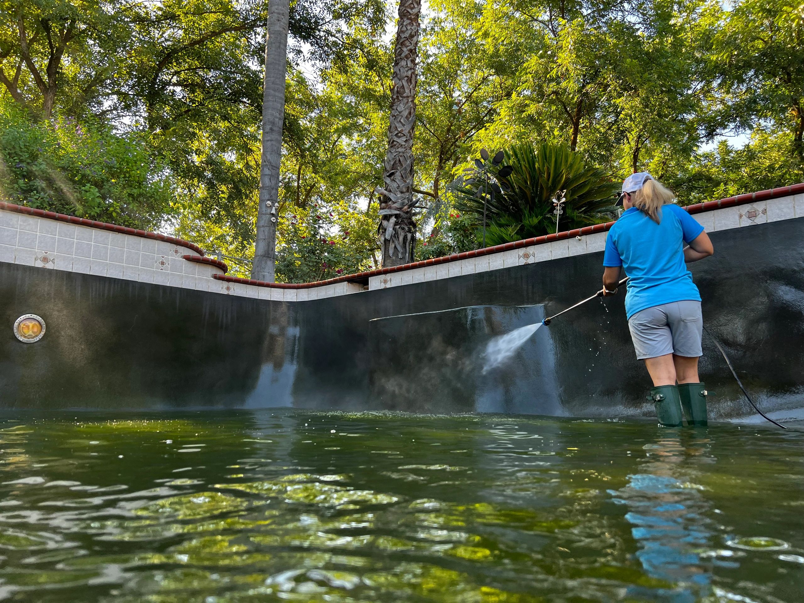 Karri power washing a green pool.