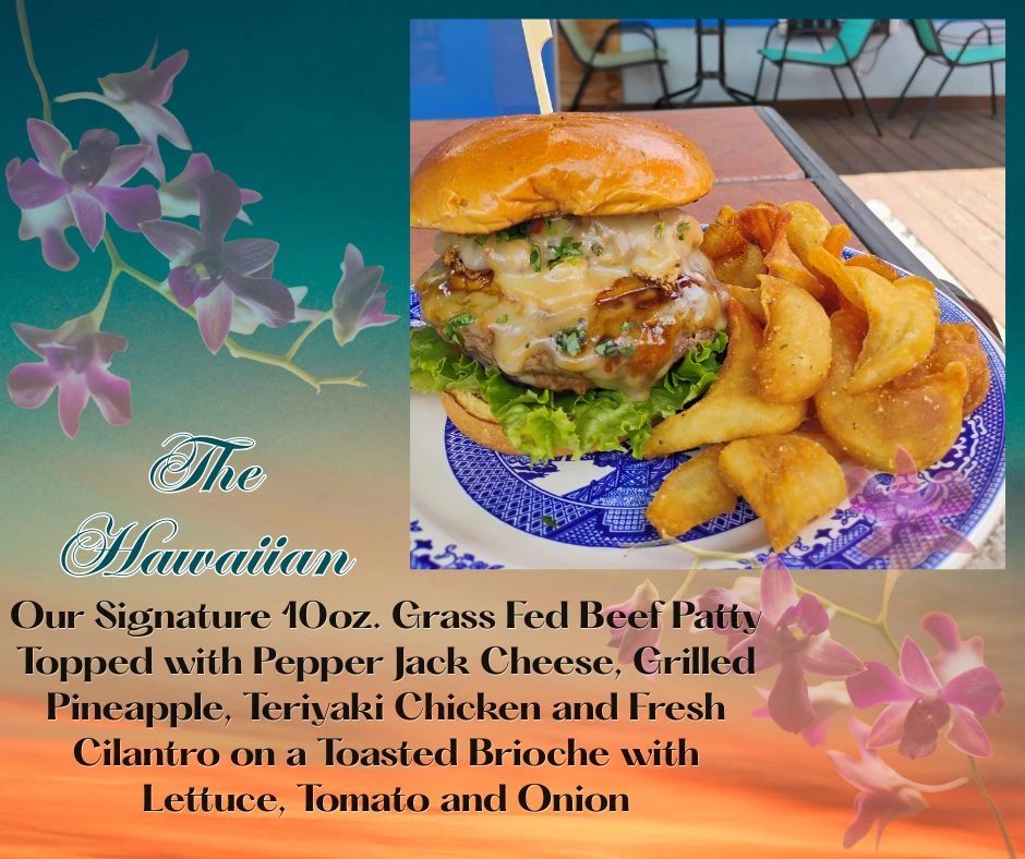 A juicy Hawaiian burger with fries on a decorative plate.