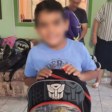 Niño con mochila de Transformers en un salón.