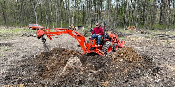 Man on Backhoe Digging Dirt