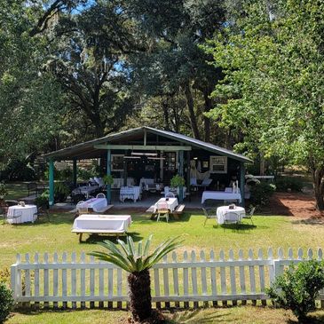 Outdoor event setup with tables and chairs under a pavilion.