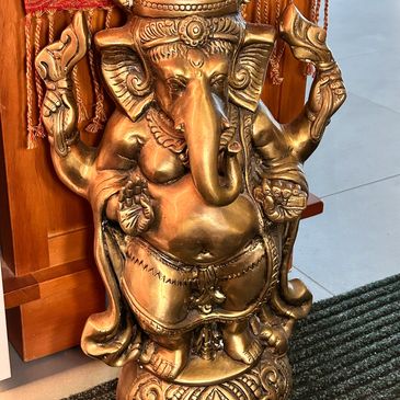 A brass statue of Lord Ganesha with intricate detailing.