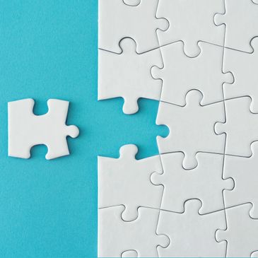 A plain white jigsaw with one piece removed.