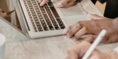 Two people working on a laptop together.